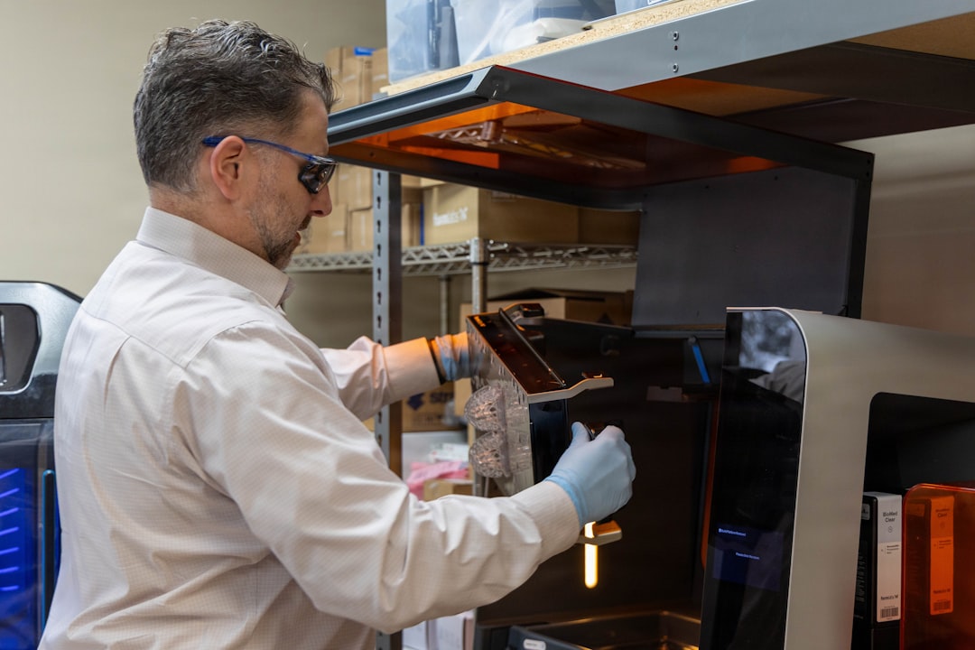 Peter Liacouras, director of services for 3D Medical Applications Center, removes surgical splints from a 3D printer at Walter Reed National Military Medical Center March 2, 2026, on Naval Support Activity Bethesda, Maryland. Walter Reeds 3D MAC uses advanced imaging design software and 3D printing to create patient-specific models, surgical guides and custom implants to support clinical decision-making and improve surgical outcomes. (DOW photo by Leticia Hopkins)
